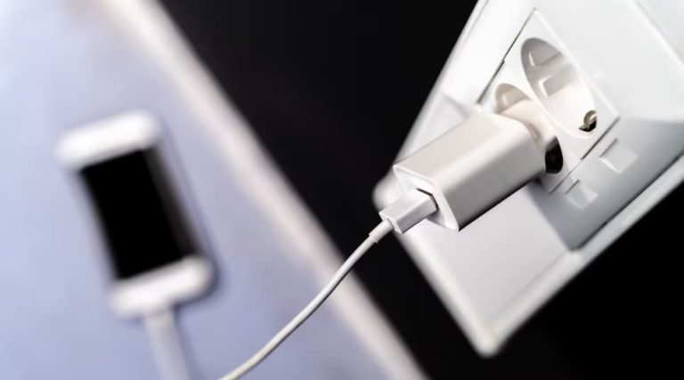 Cargador de pared y adaptador de corriente dañado con marcas de quemaduras por cortocircuito